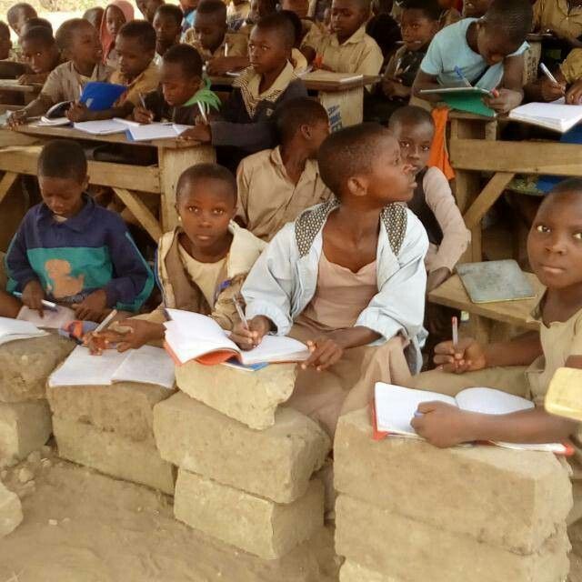 Students in green uniforms in a classroom